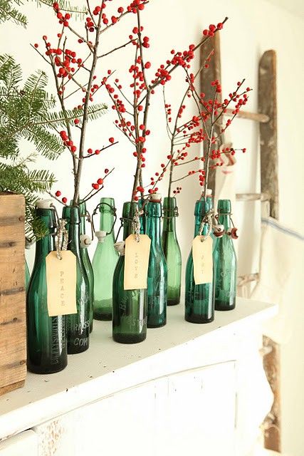 Festive green colored bottles holding branches of red berries can make a windowsil look very Christmassy
