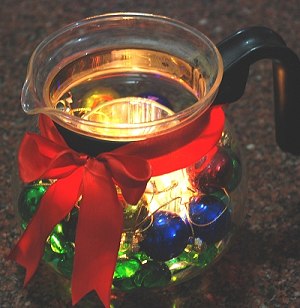 A Glass Tea Kettle is transformed into a glowing centerpiece for a Christmas table.