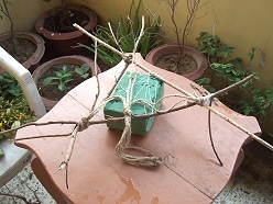 Twigs over a brick of floral foam fastened with florist wire.